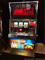 Full frontal view of slot machine showing illuminated marquee, reels, payout panel and coin tray.