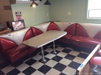 Wide shot of the corner booth and table in a room with checkered flooring.