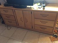 Full view of oak dresser showing six drawers and center cabinet with two doors.