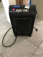Front view of Eyevac vacuum showing brand logo and power cord on tiled floor.