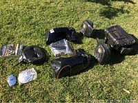 Full overview of the Harley Davidson accessories lot on grass, showing saddlebags, rear fender fairing, passenger backrests, chrome parts and hardware bag.
