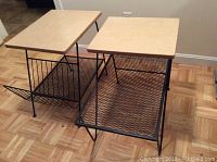 View of both vintage MCM end tables showing laminated wood tops and black metal mesh lower shelves with distressed finish.