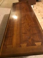 Full view of table top showing walnut veneer surface and dovetail inlay corners