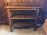 Front view of oak shelving unit showing two open shelves and backsplash