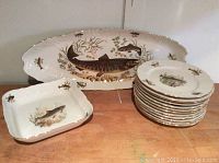 Full set displayed on table showing the oval platter behind the stack of round plates and square serving dish at side.
