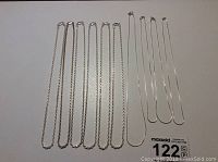 Photo showing all 10 chains laid flat including snake and rope styles with visible clasps