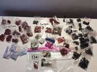 Photo showing multiple labeled plastic bags with various cabochons and beads of Carnelian, Red Jasper, Agate, Black Onyx, and Bloodstone stones.