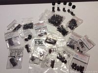 Photo showing multiple small clear plastic bags containing garnet cabochons and beads of different shapes and sizes.