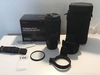 Full lot contents laid out: lens, box, pouch, strap, hood, collar, manual, filter