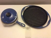 Photo shows the top view of the cast iron skinny grill with enamel handles and the mini skillet with lid on a white background.