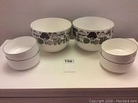 Full set of six enamel bowls displayed, two large mushroom pattern bowls and four smaller plain bowls.