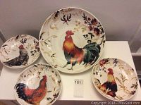 Four ceramic rooster-themed bowls arranged on a white surface.