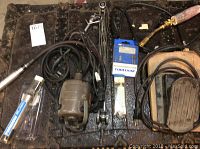 Overview photo showing Foredom motor, cords, handpiece, torch head with hose, foot pedal, and miscellaneous parts on a work mat.