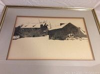 Framed dry brush of snow-covered barns in high contrast