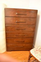 Front view of mid century six drawer wooden dresser showing drawer handles and overall condition.