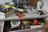 Overview of vintage kitchen items arranged on counter, bread box, mixers, bowls, and towel visible