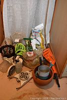 Photo of entire lot showing hedge trimmer, bags of garden supplies, planters, and other garden items