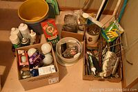 Overview of various cleaning and hardware items including buckets, broom, gloves, steel wool, and box with screws and nails.