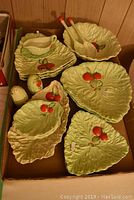 Full view of the luncheon set including plates, salad bowl, serving spoons, sauce boat, salt and pepper shakers arranged in a box.