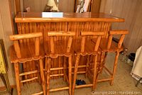Front perspective of pine topped bar and four matching stools