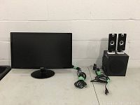 Front view of Acer 23-inch LED LCD monitor on oval stand with accompanying CA speaker set including subwoofer and two satellite speakers, all arranged on tabletop.