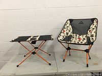 Full view of collapsible chair and table showing mushroom print fabric and orange frames.