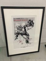Framed artwork showing The Zombie Survival Guide Recorded Attacks print with zombie illustration and author signature in red ink.