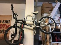Full side view of full sized BMX bike hung on wall showing black and white frame and seat.