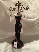 Full view of the dress form jewellery stand showing the black velvet evening dress with red lace detail and gold twisted metal arms for hanging jewellery.