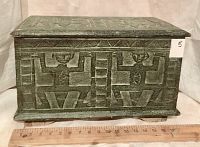 Front and side view of the hope chest showing carved Aztec humanoid and geometric designs painted in antique green on soft wood.