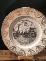 Full view of commemorative plate with gold decorative rim and scale showing size