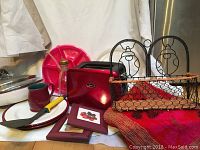 Full view of colorful kitchen lot showing red Oster toaster, ladybug wire basket, floral mat, plates, small pictures, Tupperware and spatula.