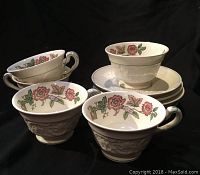 Set of five Wedgwood cups with matching saucers featuring floral Patrician Tapestry pattern, shown against black background.