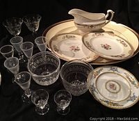Mix of Waterford crystal liqueur glasses, Paragon plates, dessert glasses, serving tray and gravy boat arranged on dark background