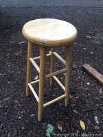 Full view of wooden stool showing four legs and seat