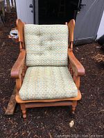 Front view of solid wood low height chair with patterned fabric cushions on seat and backrest.