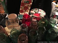 Santa layered dessert tray, colored Mason jars, red glass candle holder, and Norman Rockwell plate visible in image with holiday napkins in the background.