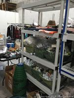 Five plastic shelving units in a storage/warehouse space with various items on and around shelves, showing shelving condition and size.