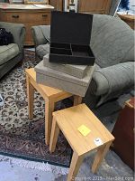 Two yellow wooden stacking side tables with linen-look storage boxes arranged on and next to tables.