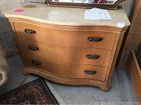 Front angle view of the solid oak 3 drawer dresser showing curved front and marble top with stain.