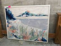 Full view of framed painting showing a coastal landscape with water, shoreline vegetation, and distant houses under a soft sky.