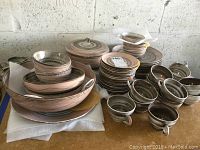 Photo showing full set of Santa Ana Vreni stoneware including stacked plates, bowls, cups grouped together on table.