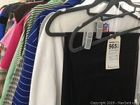 Assorted golf clothes on hangers including shirts and jackets in various colors and sizes