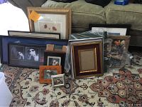 Full lot showing assorted picture frames and pictures on carpeted floor