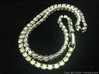 Full view of the vintage single strand rhinestone necklace choker laid out in a circle showing the sparkle of rhinestones and metal links.