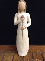 Front view of the Willow Tree Love figurine showing the whole figure holding a rose to the chest
