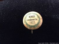 Front view of the 1922 Lansdowne Fair member pin showing text and green laurel wreath decoration.