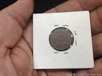 Reverse side of 1933 Canadian one cent penny showing denomination and year in white cardboard holder.