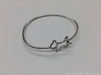 Full view of the thin sterling silver bangle cuff bracelet featuring a simple Scotty dog outline in wire form.