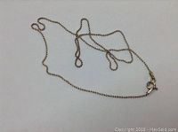 Sterling silver chain displayed spread out on a white surface showing the tubular beaded design and spring ring clasp.